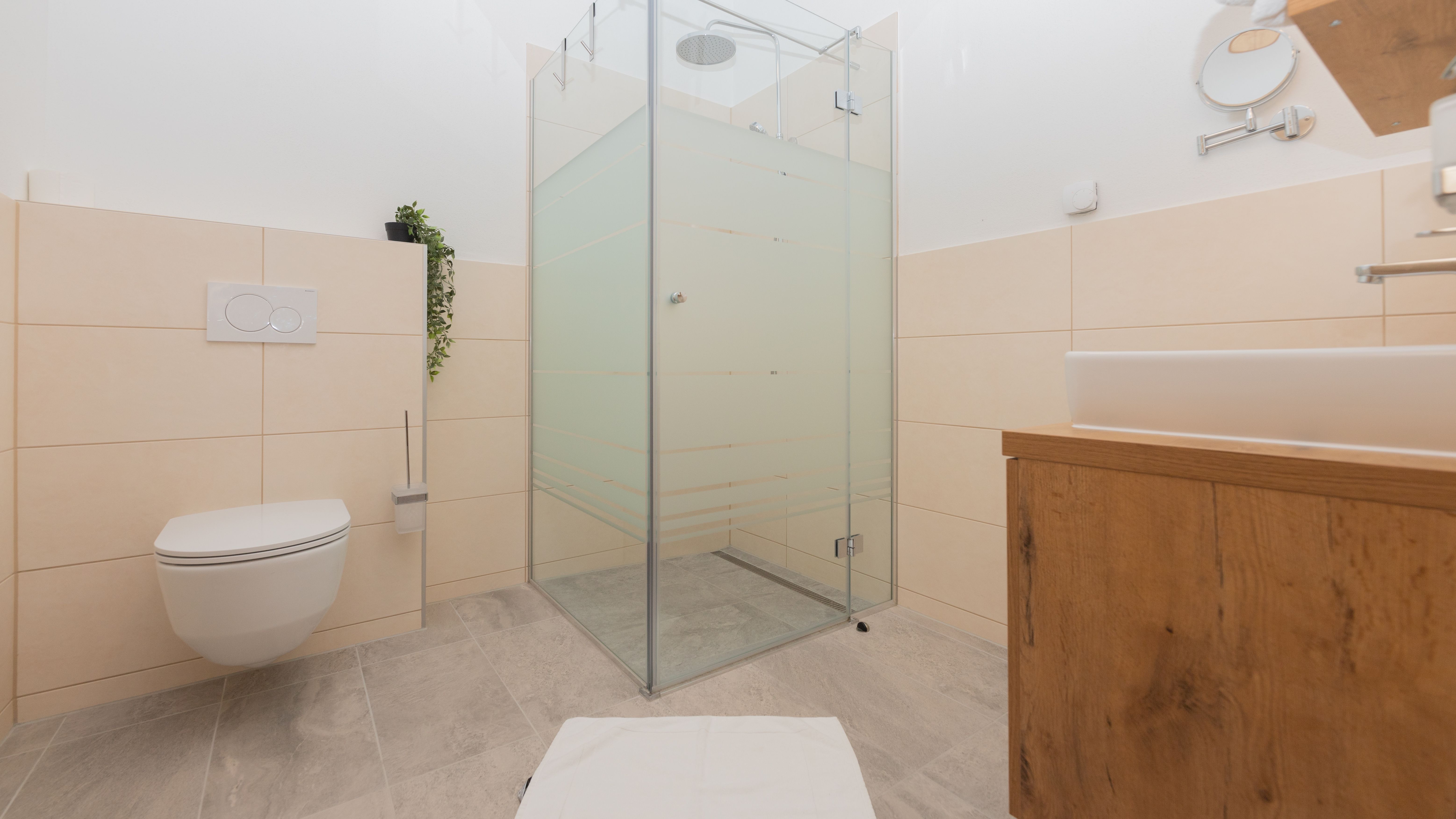 Modernes Badezimmer mit Dusche, Toilette und Waschbecken.
