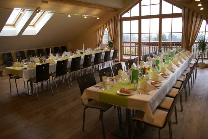 Ein festlich gedeckter Saal mit langen Tischen und Stühlen in einem Landgasthaus.