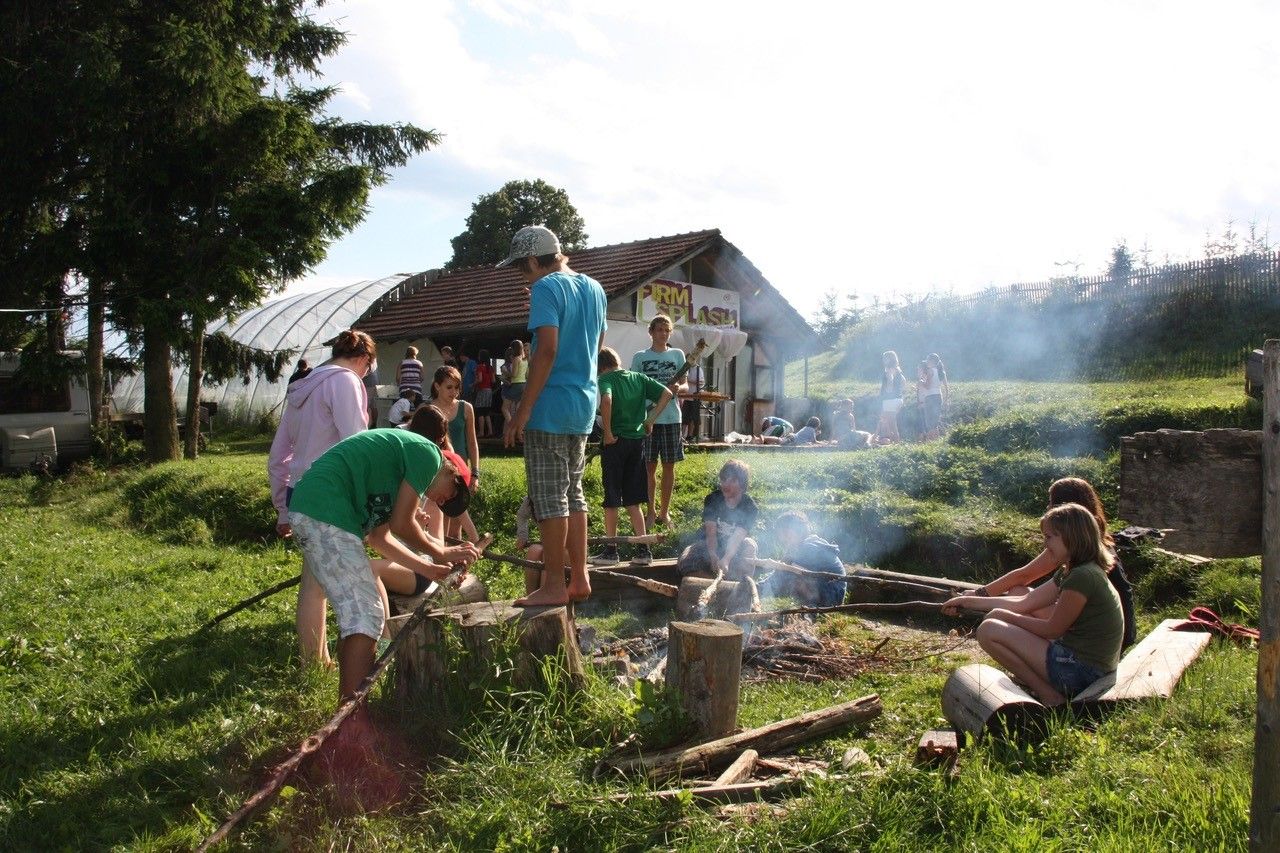 Gruppe von Menschen an einem Lagerfeuer auf einem Campingplatz.