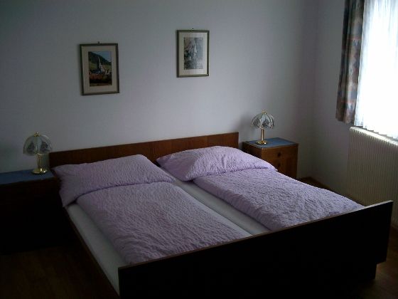 Ein Schlafzimmer mit einem Doppelbett, zwei Nachttischen und zwei Tischlampen.
