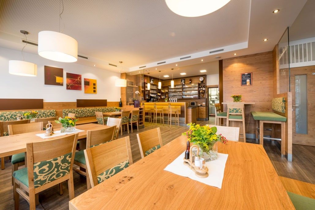 Innenansicht eines gemütlichen Gasthauses mit Holzmöbeln und Bar.