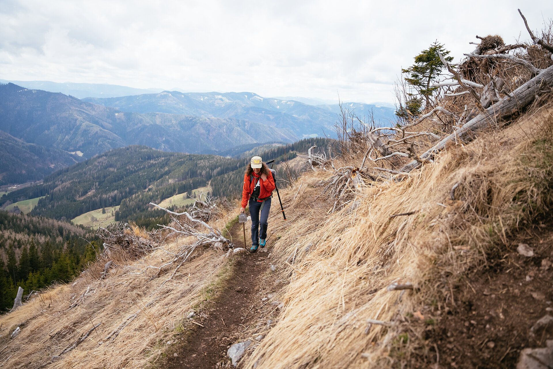 Ein sanfter Pfad schlängelt sich durch die beeindruckende Berglandschaft, während die Wanderin mit jedem Schritt die frische, klare Luft einatmet. Die sanften Hügel und die majestätischen Gipfel der Wiener Alpen bieten eine atemberaubende Kulisse, die zum Verweilen und Staunen einlädt.