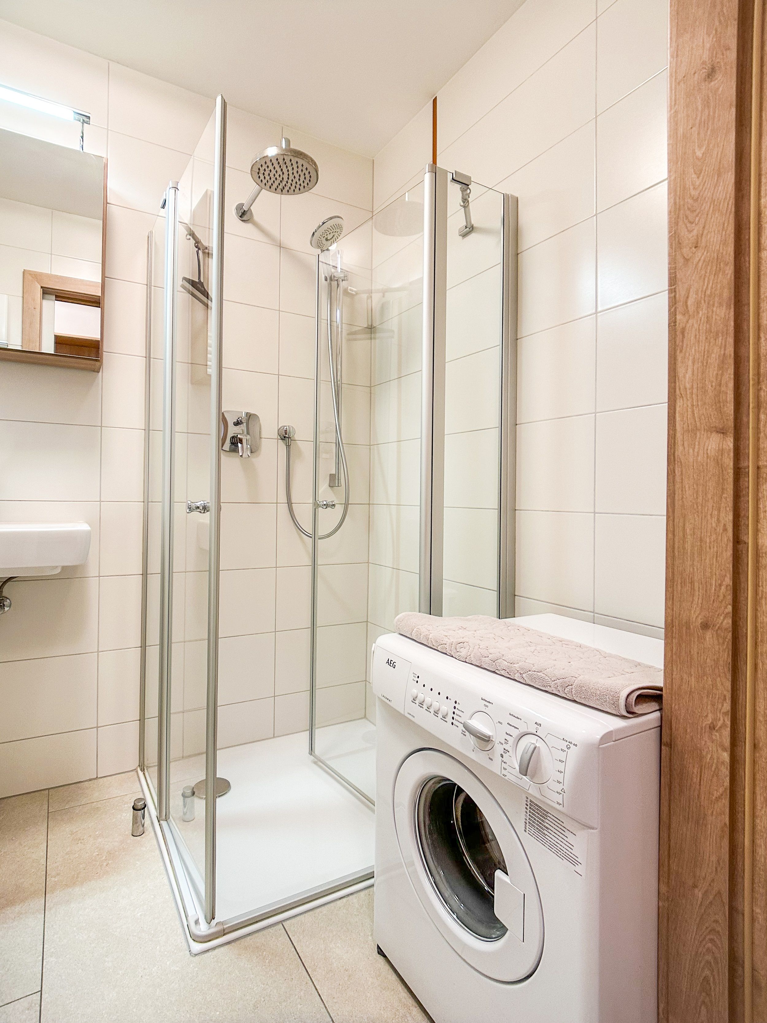 Modernes Badezimmer mit Dusche und Waschmaschine.