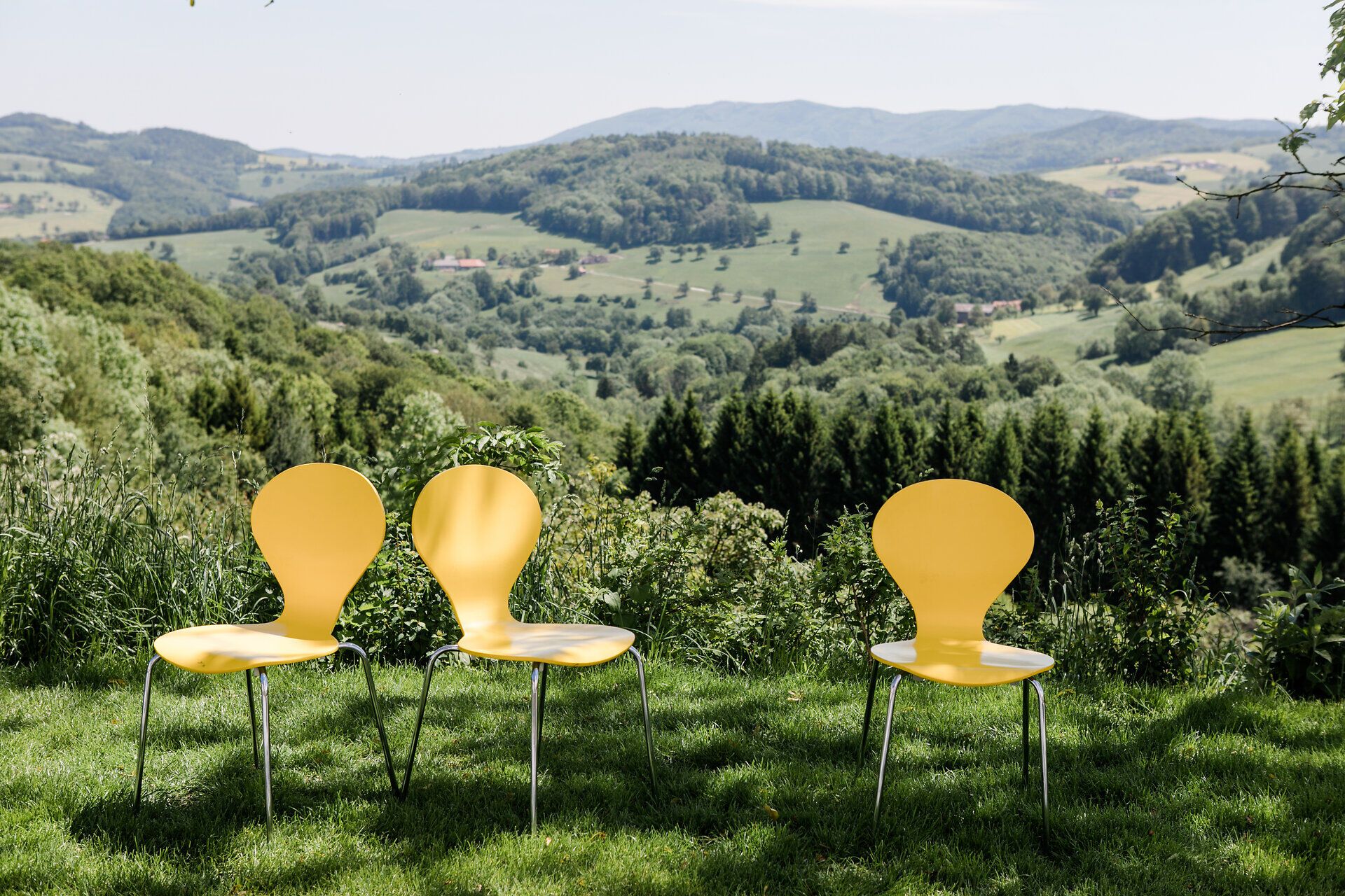 Inmitten der sanften Hügel des Mostviertels laden leuchtend gelbe Stühle dazu ein, die atemberaubende Aussicht zu genießen. Die frische Bergluft und das sanfte Rauschen der Natur schaffen eine perfekte Kulisse für entspannte Momente im Freien.