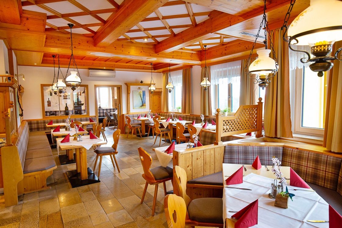 Gemütliches Restaurant mit Holzmöbeln und gedeckten Tischen.