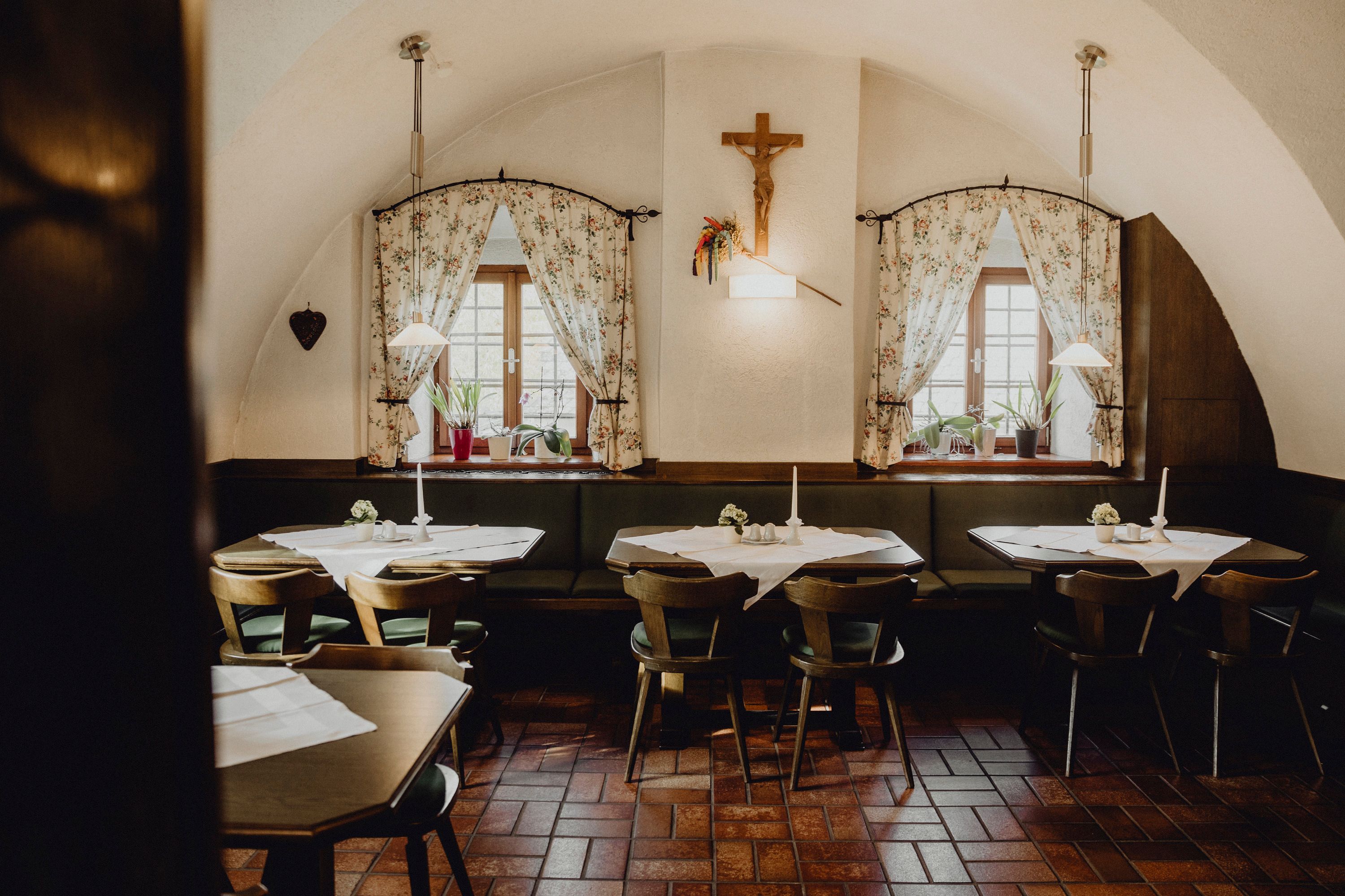 Gemütliches Gasthaus mit Holzmöbeln und dekorativen Vorhängen.