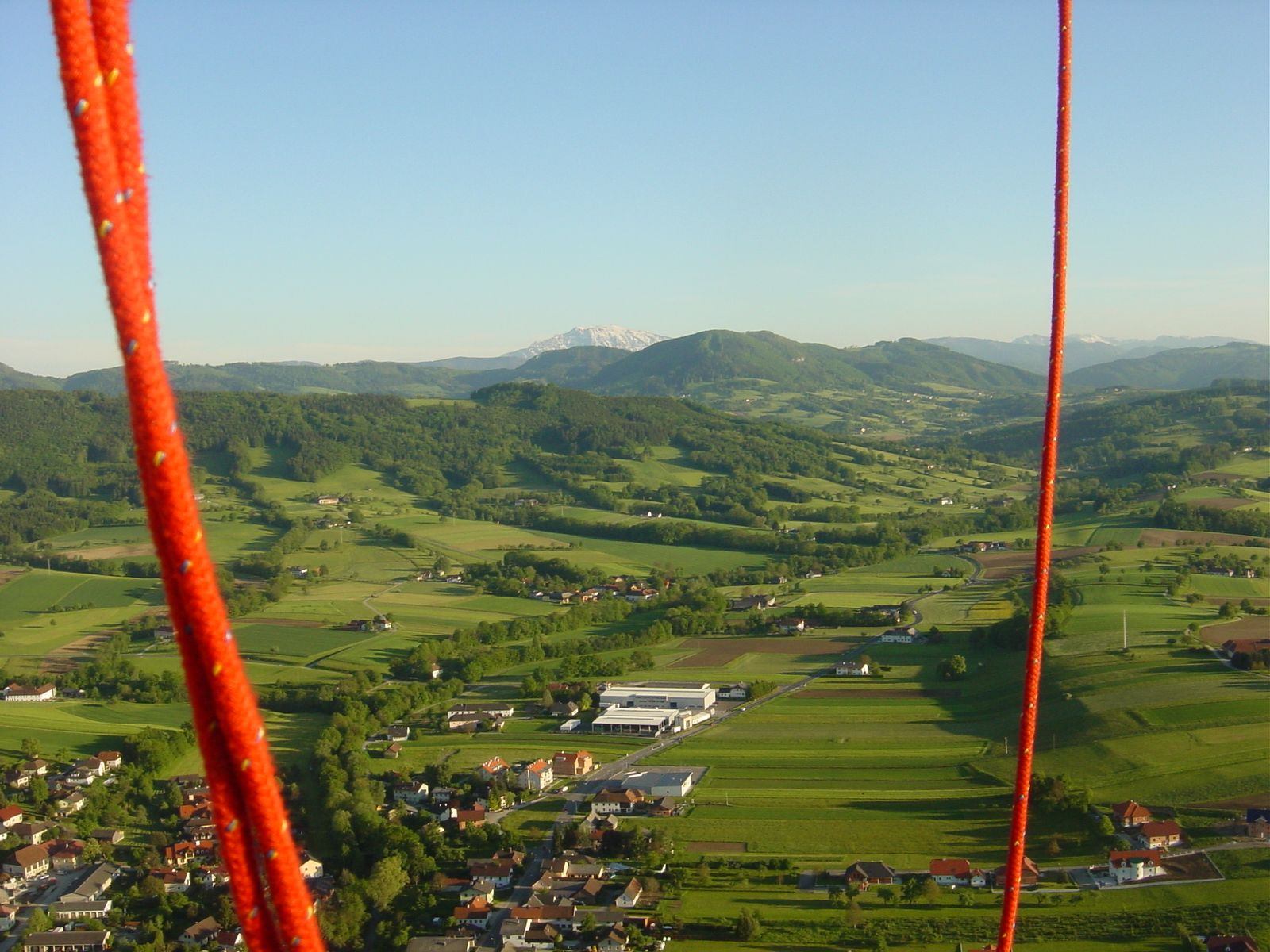 Landschaft im Mostviertel aus einem Heißluftballon mit roten Seilen im Vordergrund.