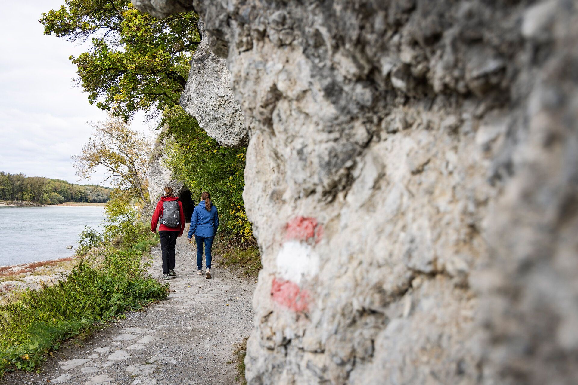 Zwei Frauen auf einem Wanderweg neben der Donau. 