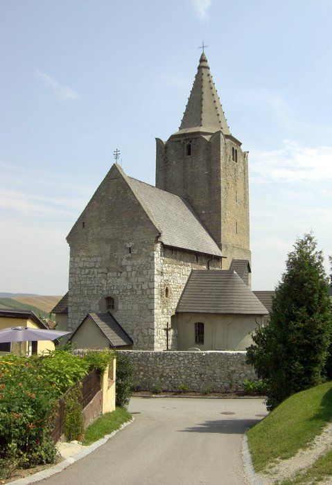 Historische Wehrkirche mit steinernem Turm und Spitzdach.