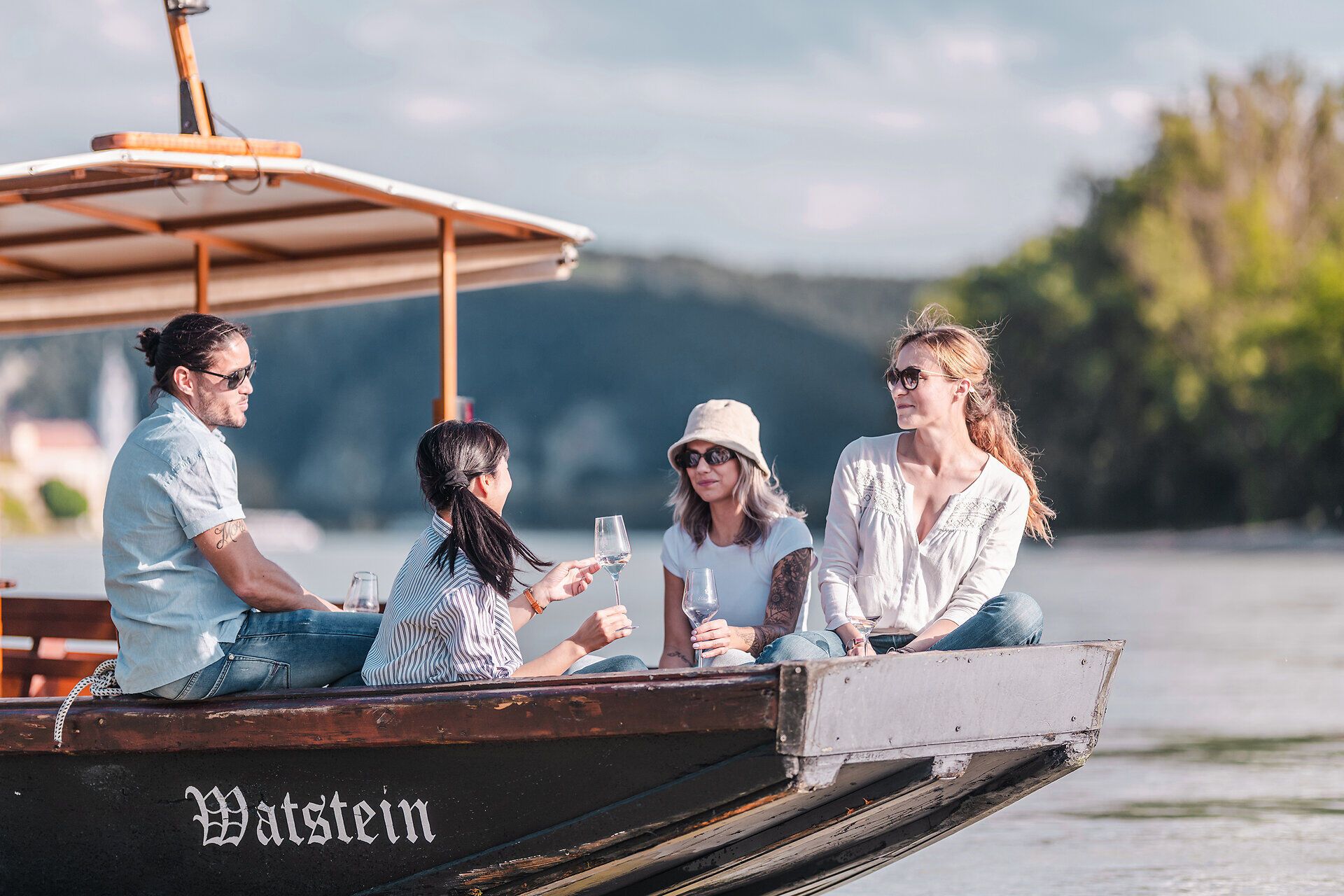 Eine Holzzille mit Menschen fährt auf der Donau in der Wachau.