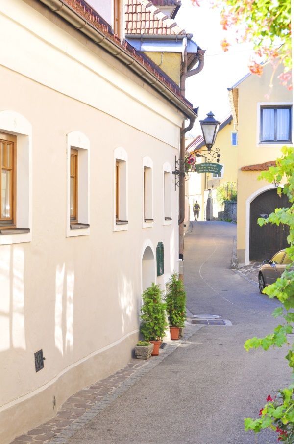 Schmale Gasse in der Wachau mit gelben Häusern und Laterne.