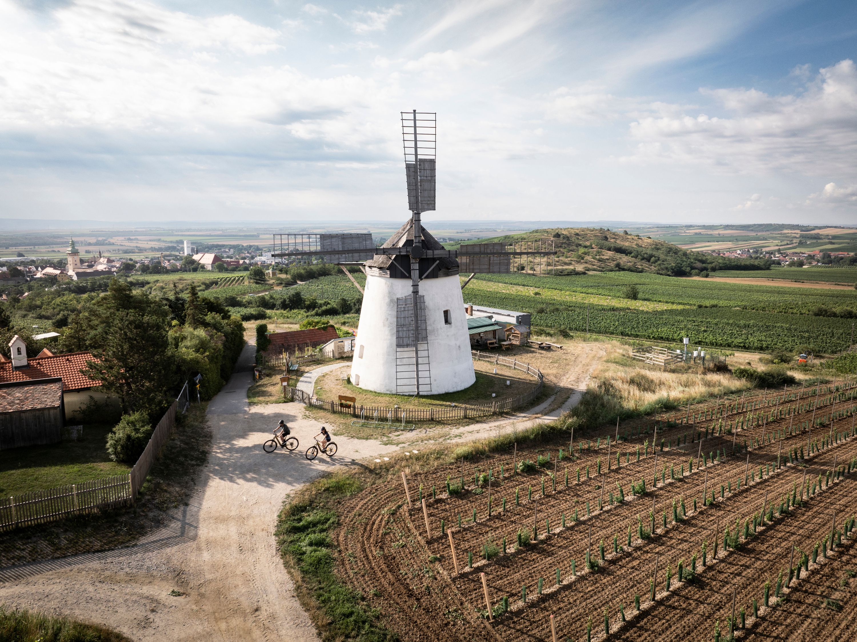 Landschaft mit Windmühle und Radfahrern in Retz, Österreich.