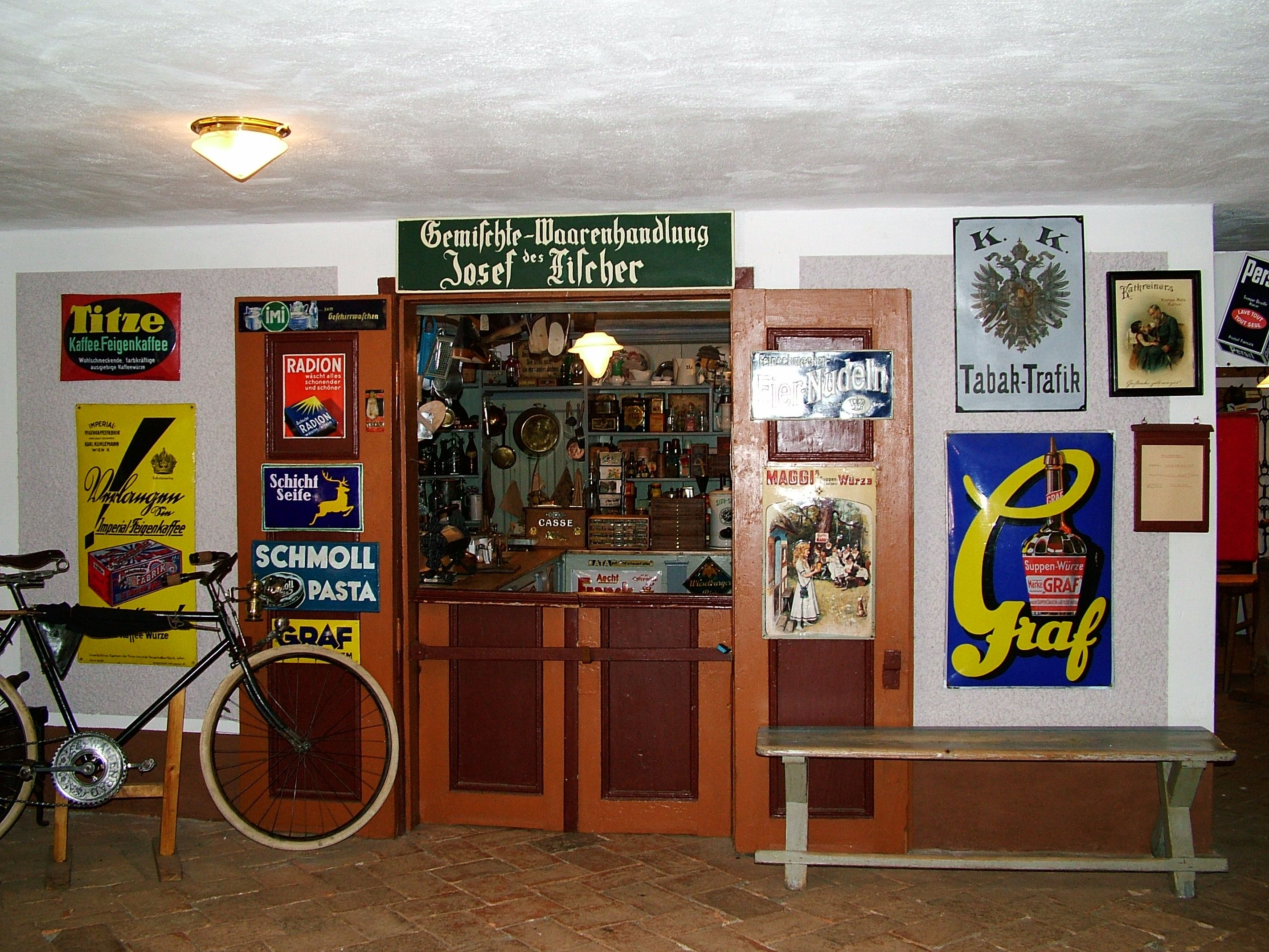 Historischer Laden im Mostviertler Bauernmuseum mit alten Werbeschildern und einem Fahrrad.