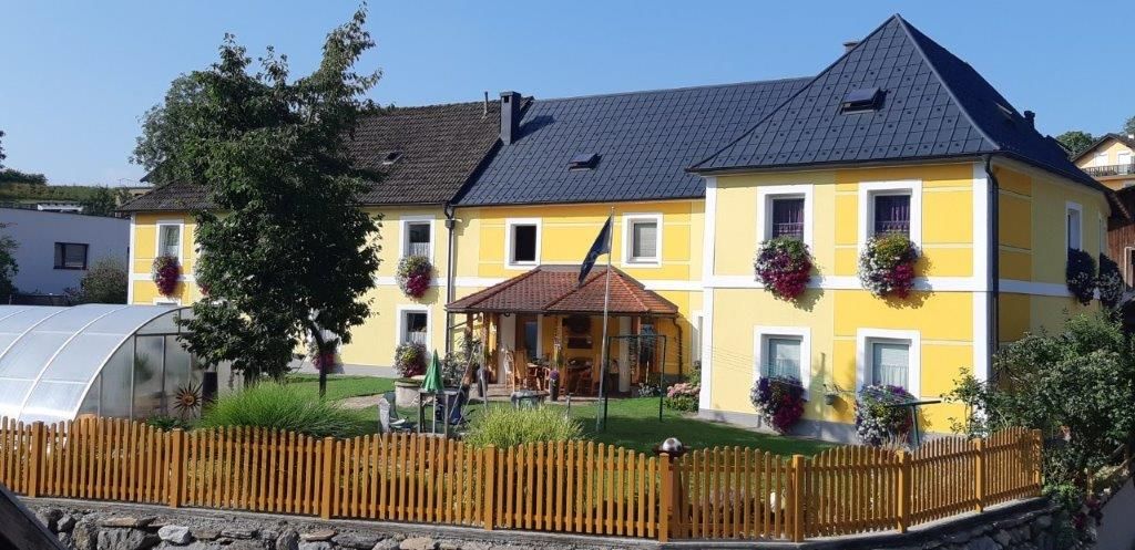 Gelbes Haus mit Garten und Holzzaun