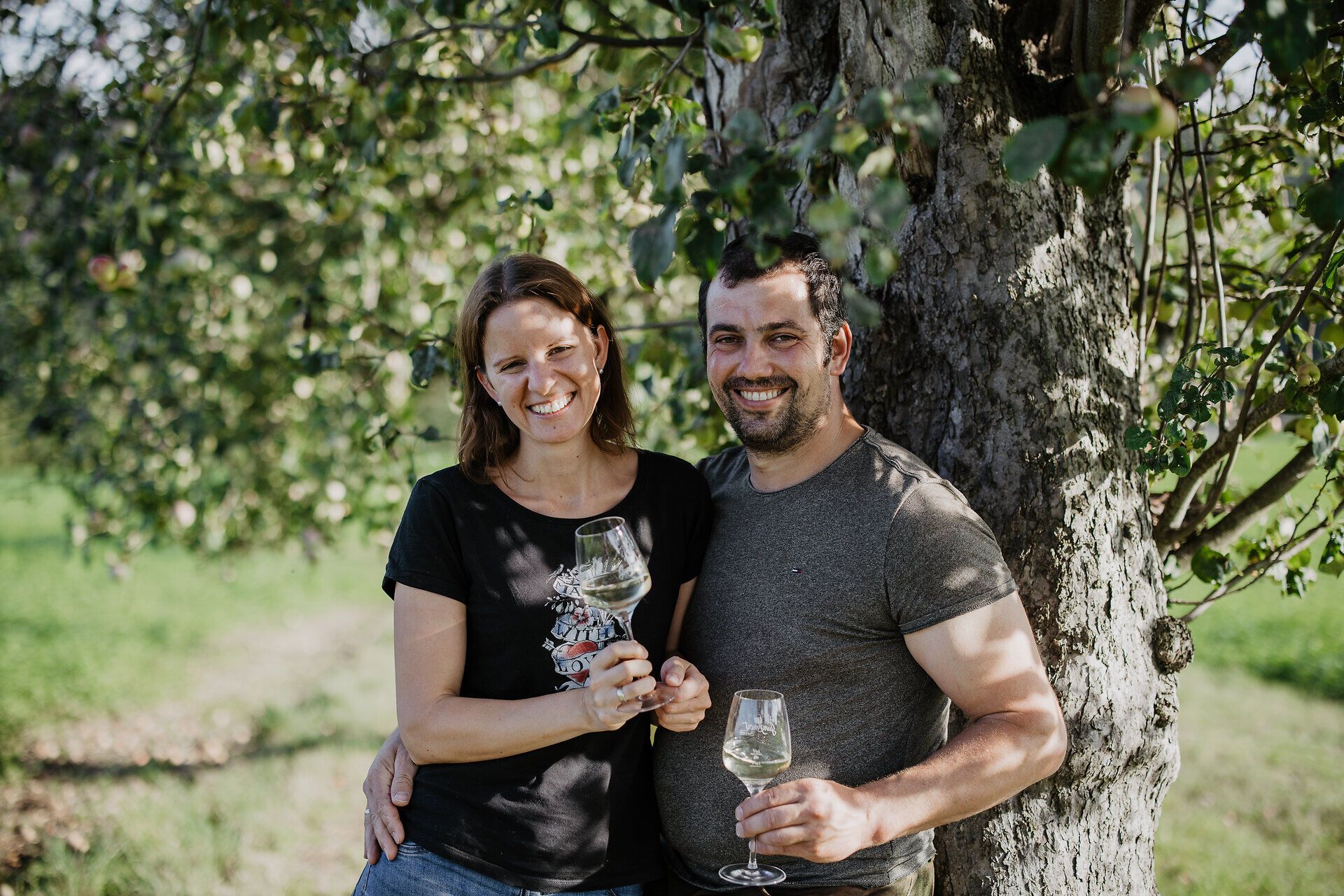 Inmitten der saftigen Wiesen und blühenden Obstbäume genießen Bernadette und Peter Haselberger ein Glas köstlichen Birnenmost. Die warme Sonne strahlt auf die beiden, während sie die idyllische Atmosphäre ihres Mostbetriebs erleben. Ein perfekter Moment, um die Aromen der Region zu feiern.
