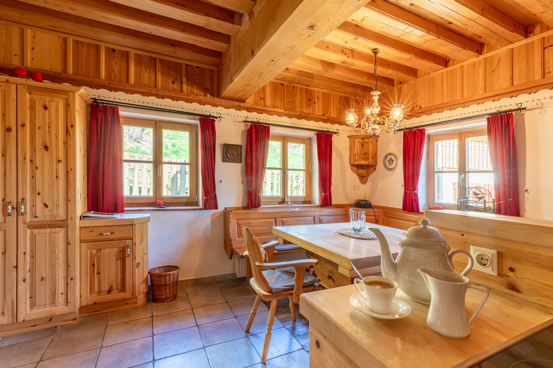 Essbereich in traditionellem Stil mit Holzmöbeln und roten Vorhängen.