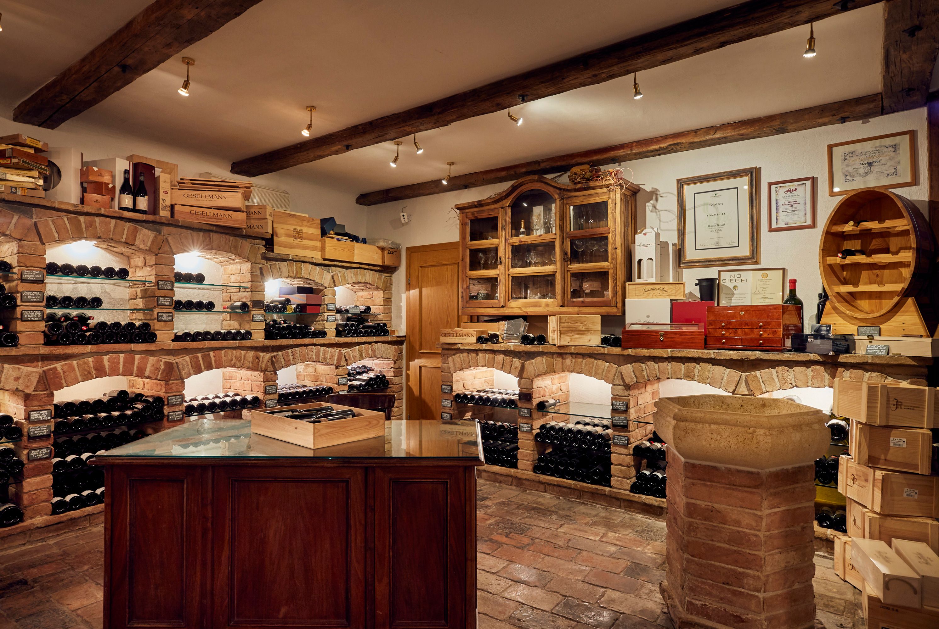 Weinkeller mit Backsteinregalen und Weinflaschen.