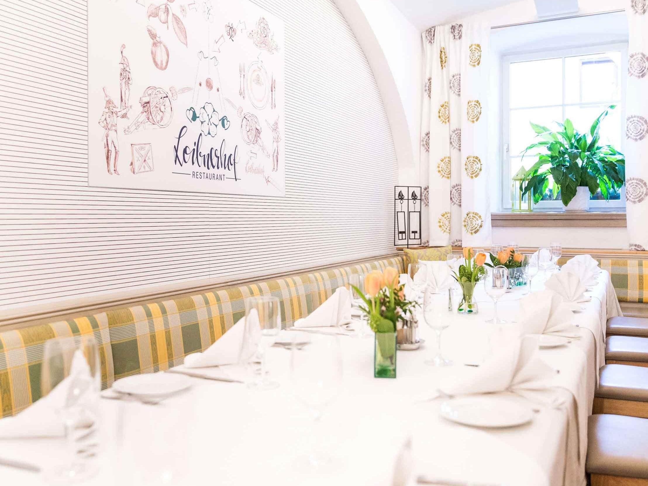 Elegantes Restaurantinterieur mit gedecktem Tisch, Blumen und Fenster mit Pflanze.