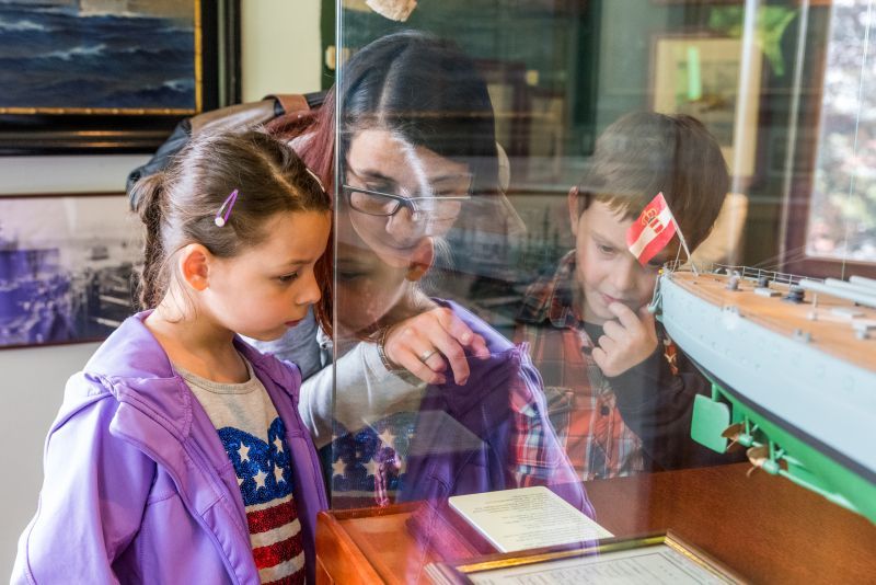 Kinder betrachten ein Schiffsmodell in einem Museum.