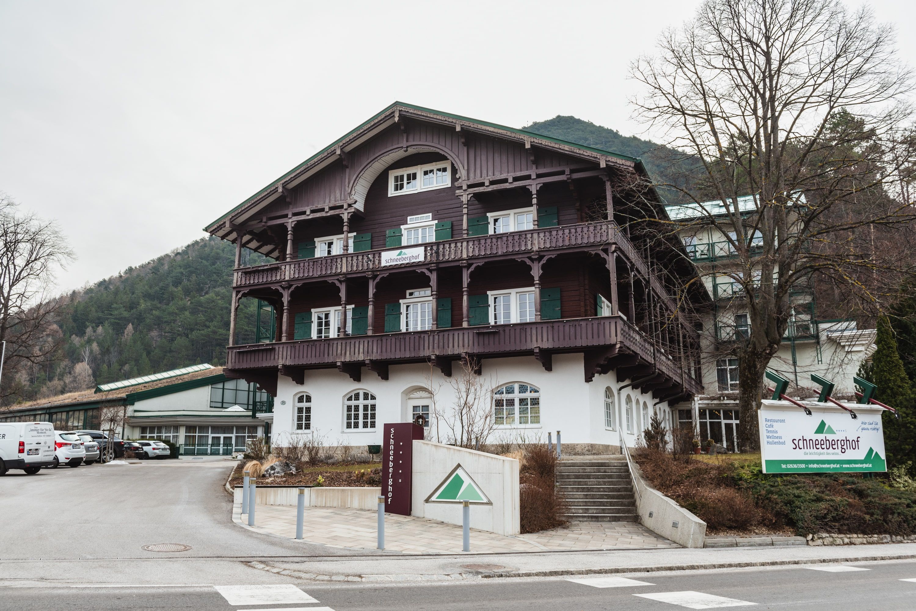Hotel Schneeberghof in einer bergigen Umgebung mit traditioneller Architektur und einem großen Schild vor dem Gebäude.