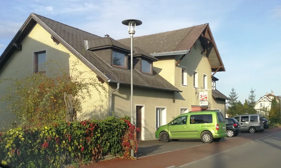 Gasthaus Kern in Prinzersdorf mit geparkten Autos und Laterne.