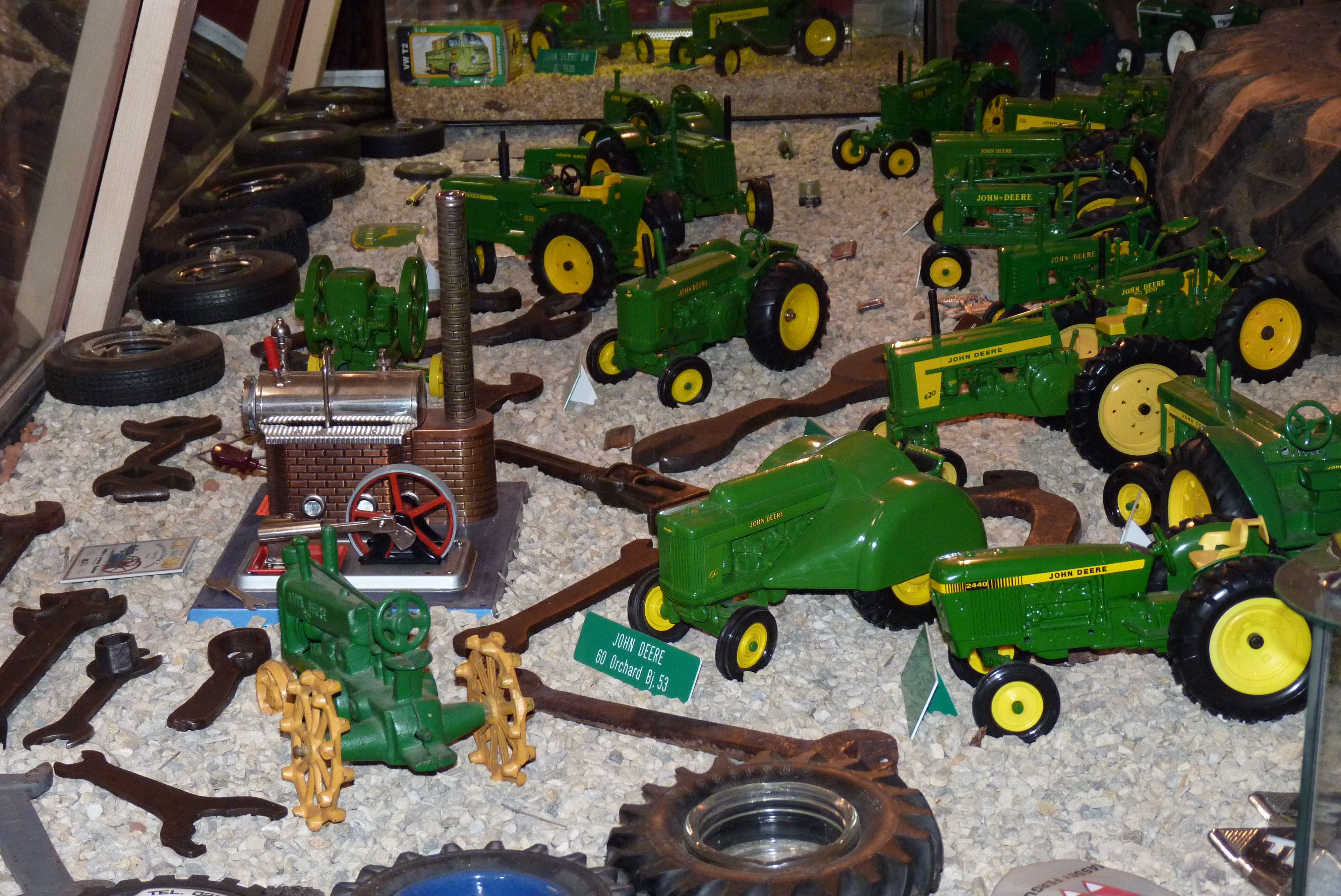 Sammlung von Modelltraktoren auf Kies ausgestellt.