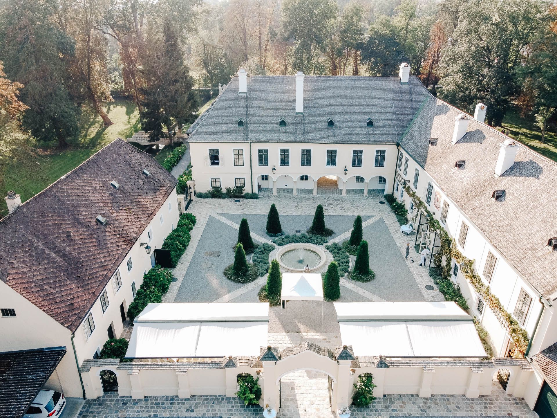 Luftaufnahme eines historischen Schlosses mit Innenhof und Garten.