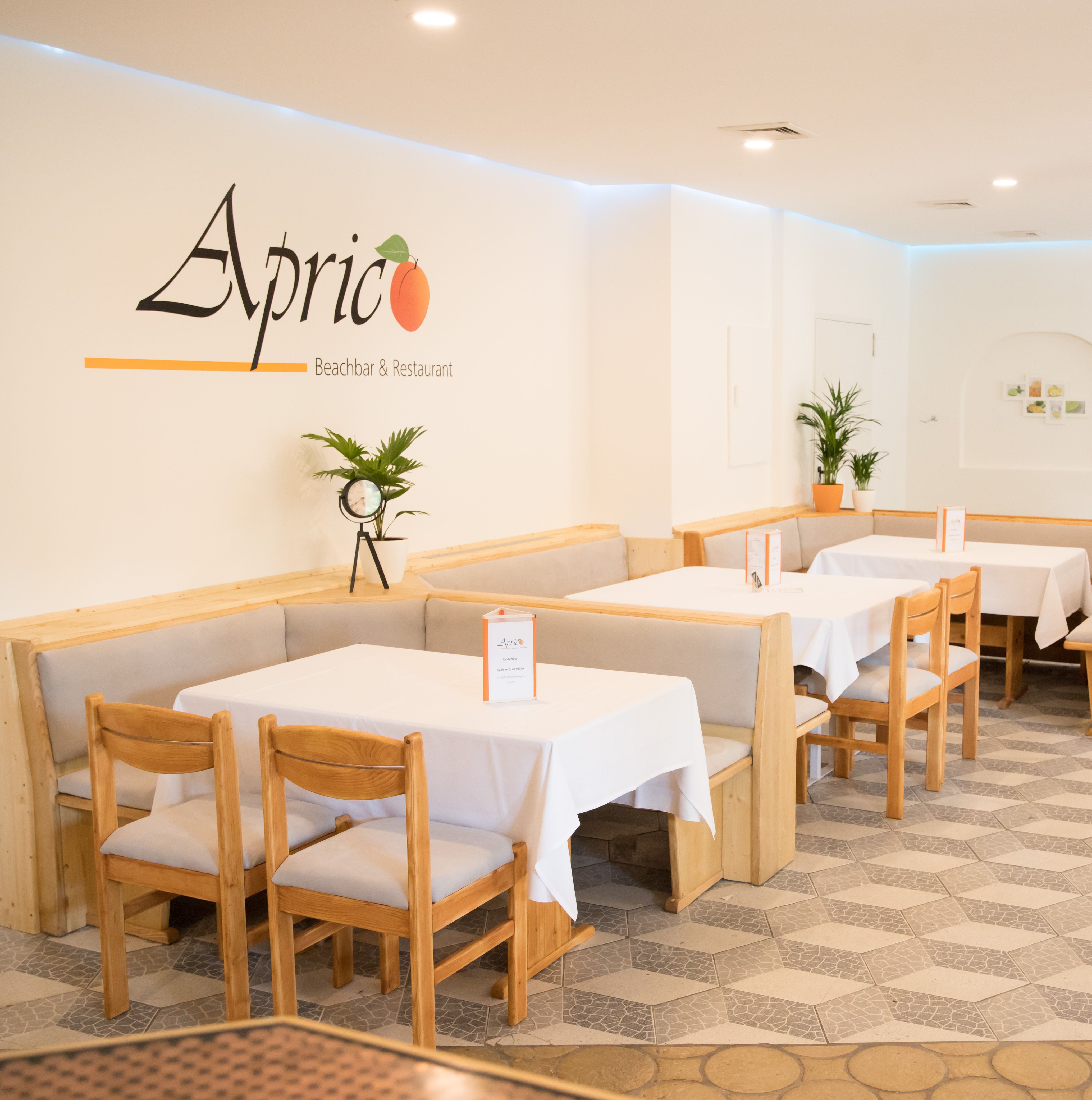 Gastraum mit Tischen und Stühlen sowie weißer Tischwäsche 