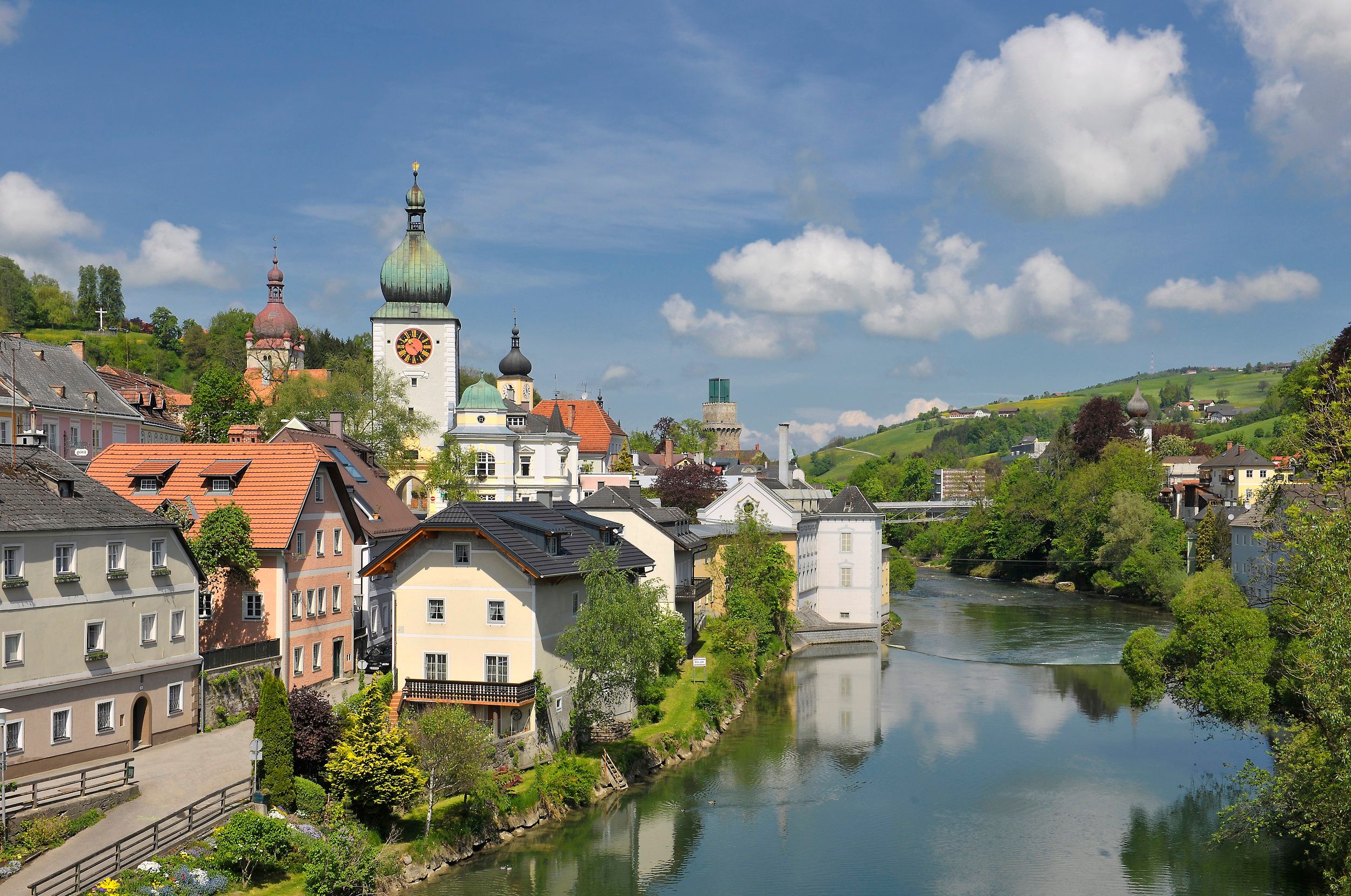Panorama von Waidhofen an der Ybbs mit Fluss, Kirchturm und grünen Hügeln.