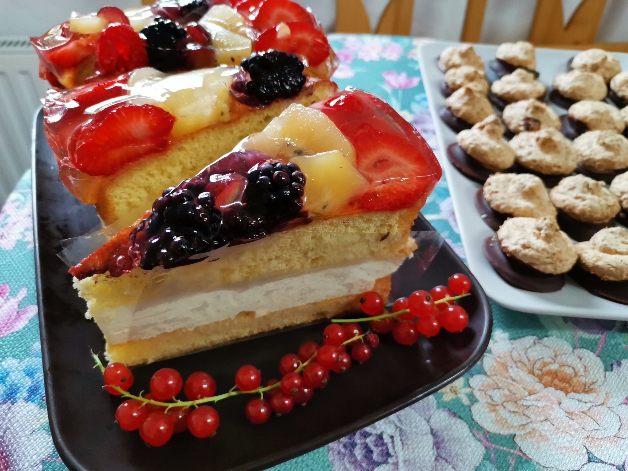 Obstkuchen mit Beeren und Kekse auf einem Tisch.