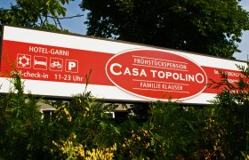 Schild der Frühstückspension Casa Topolino mit Kontaktinformationen und Öffnungszeiten.