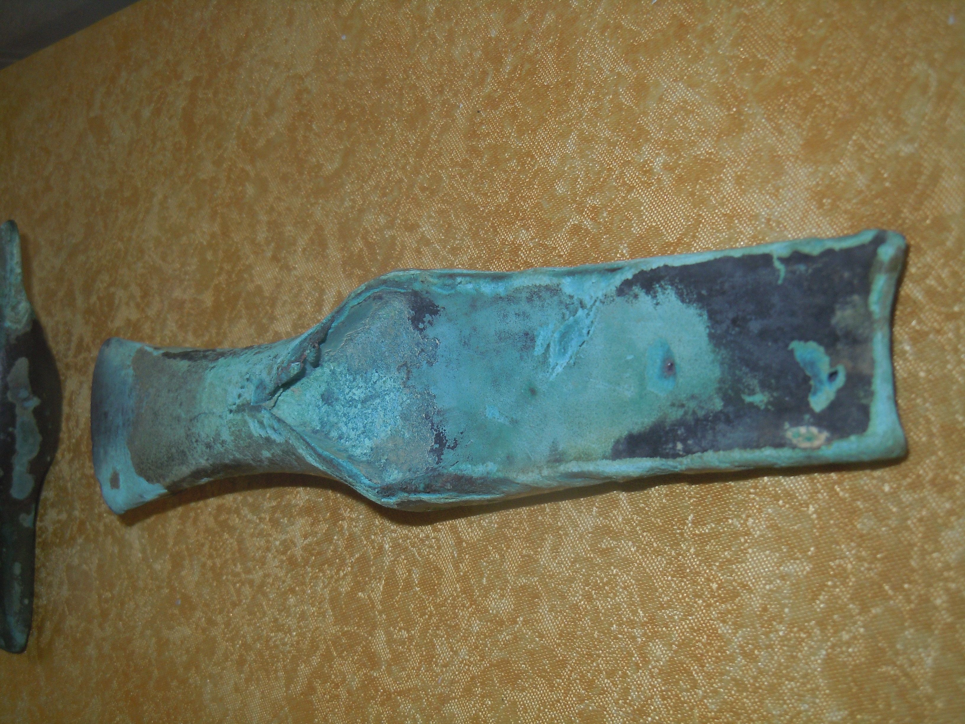 Ein altes, oxidiertes Metallwerkzeug auf gelbem Hintergrund.