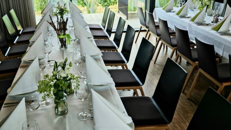 Eleganter gedeckter Tisch in einem Raum mit Blick auf Weinberge.