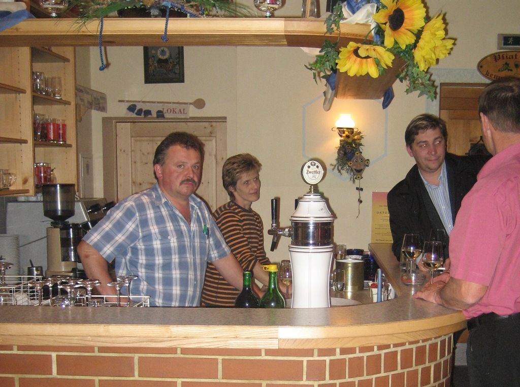 Innenansicht eines Heurigen mit Menschen an der Bar.