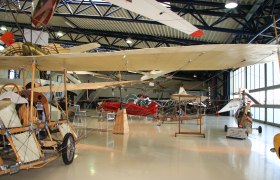 Innenansicht eines Flugmuseums mit historischen Flugzeugen und Segelflugzeugen.