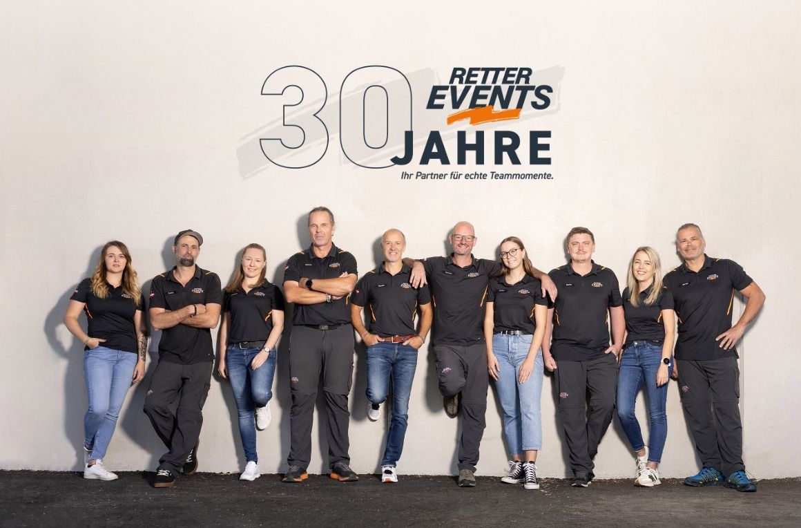 Gruppe von zehn Personen in schwarzer Kleidung vor einer Wand mit dem Logo von RETTER EVENTS und dem Text '30 Jahre'.