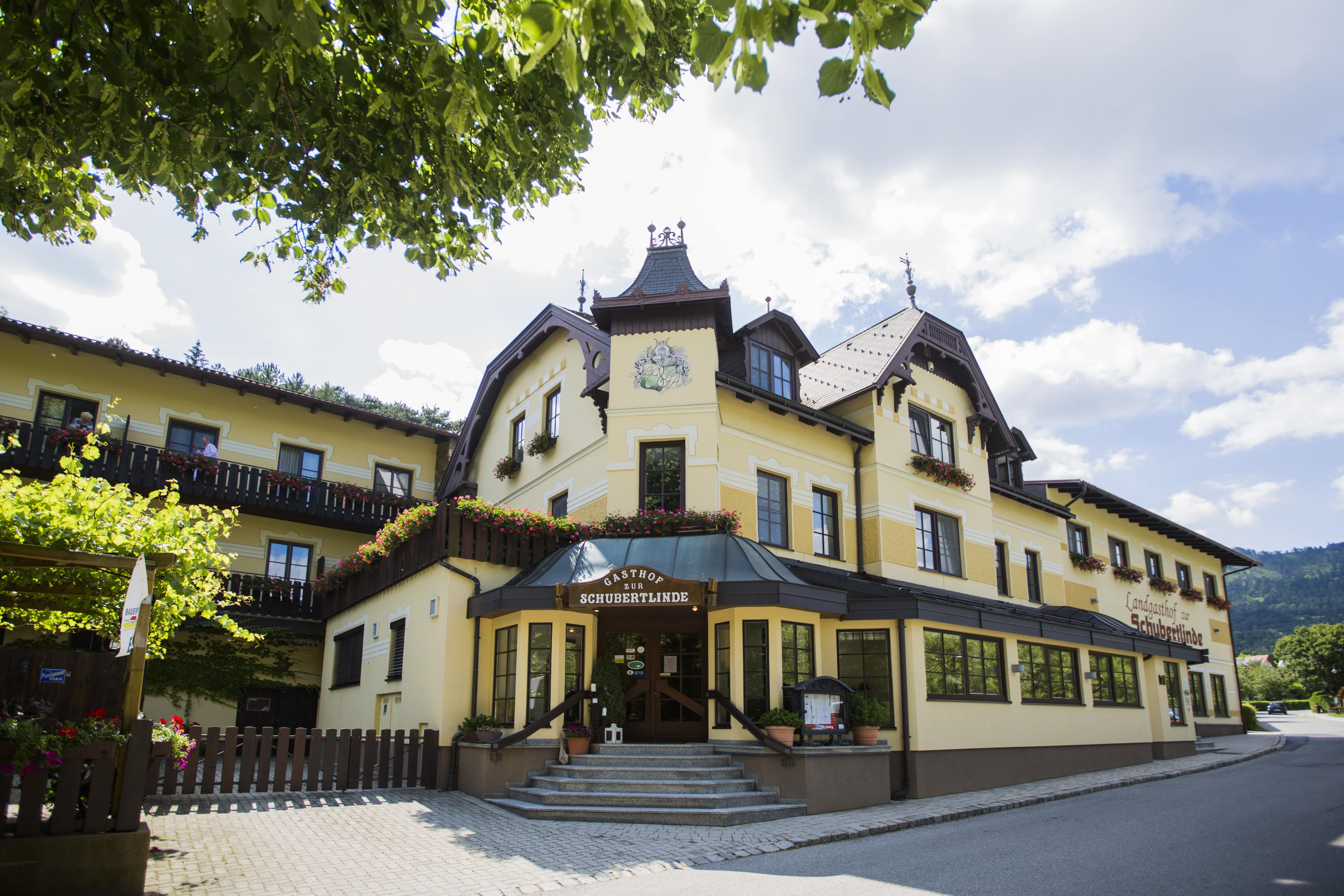 Gelbes Gasthaus mit Blumen und blauen Himmel.