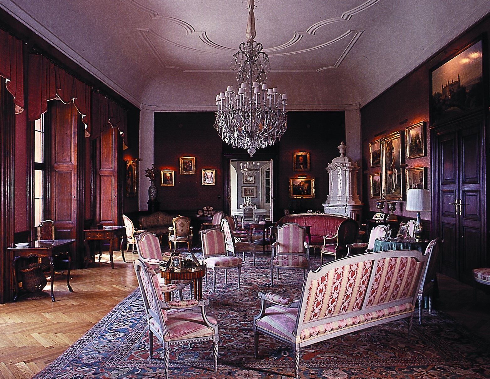 Eleganter Salon mit antiken Möbeln, Kronleuchter und Gemälden.