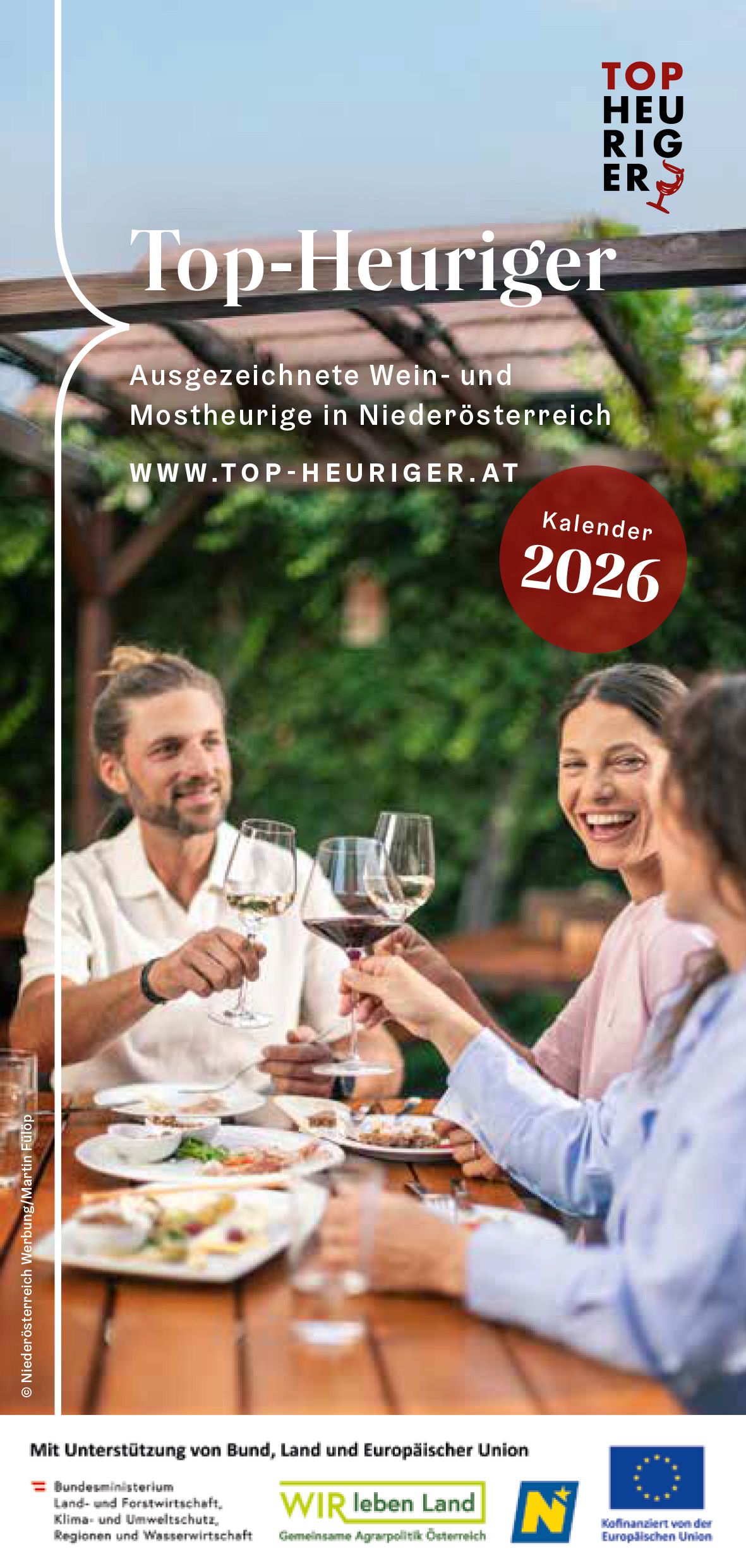 Coverbild: 3 Personen sitzen an einem mit einer kalten Jause gedeckten Heurigentisch und stoßen mit einem Wein an.