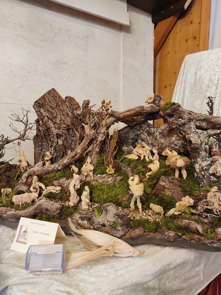 Eine Krippenlandschaft aus Wurzeln und Moos mit kleinen Figuren.