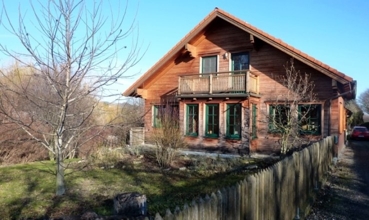 Gästehaus Fries, © Daniel Fries Holzhaus mit Balkon und Garten, umgeben von einem Holzzaun.