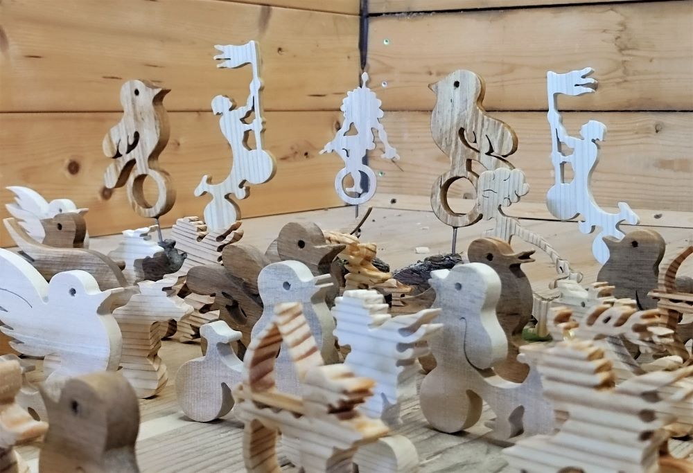 Holzfiguren in Tier- und Menschenform auf einem Holztisch.