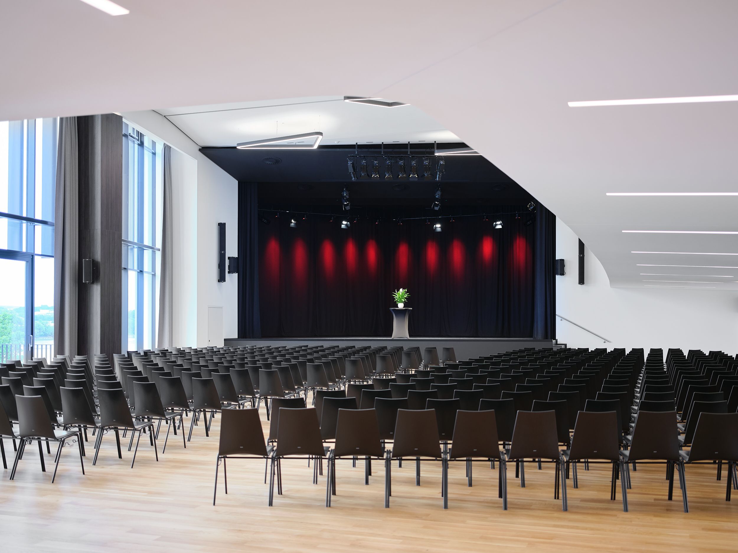Leerer Veranstaltungsraum mit Bühne und Stuhlreihen in der Stadthalle Ybbs.