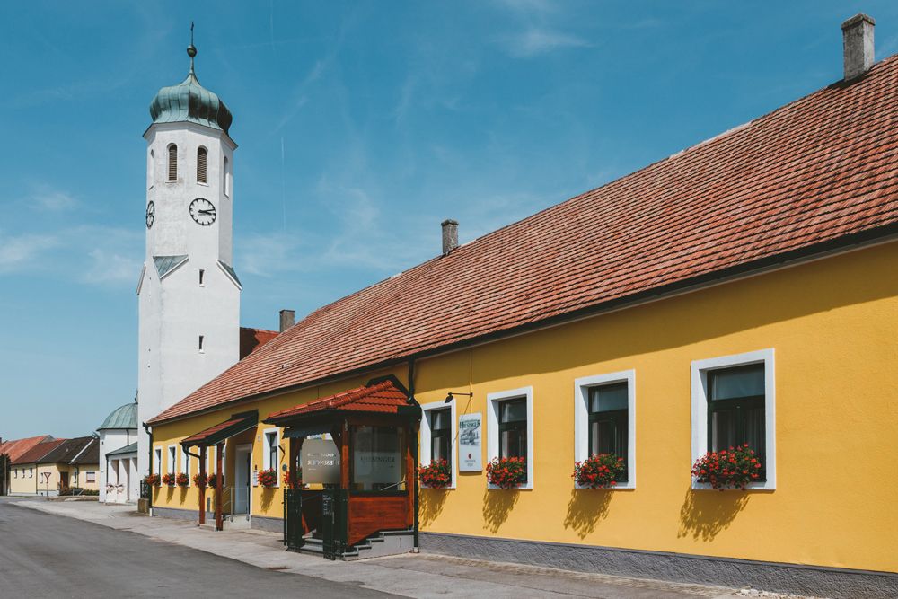 Gelbes Gebäude mit Kirchturm und blauen Himmel in einer Stadtansicht.