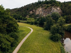 Zwei Personen wandern entlang der Thaya umgeben von m&auml;chtigen Felsen und B&auml;umen