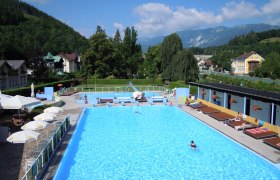 Freibad Payerbach mit Schwimmern und umliegender Landschaft.