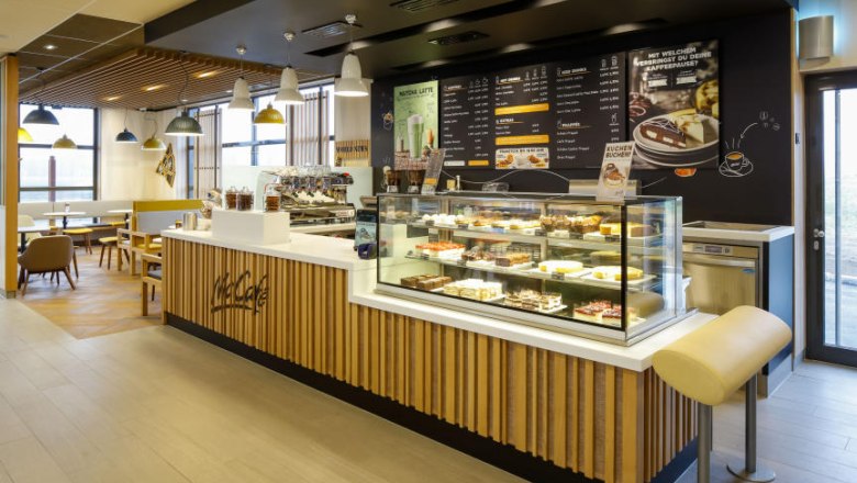 Innenansicht eines McCaf&eacute; mit Theke und Sitzbereich.