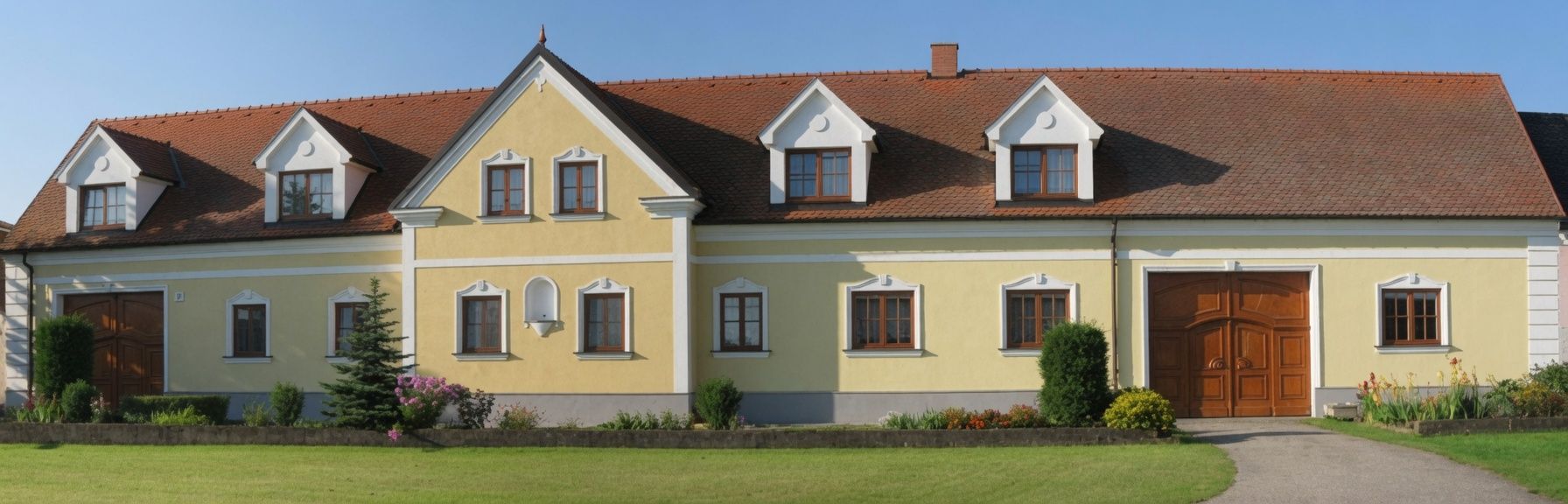 Gelbes Haus mit rotem Ziegeldach und mehreren Fenstern, umgeben von einem gepflegten Garten.