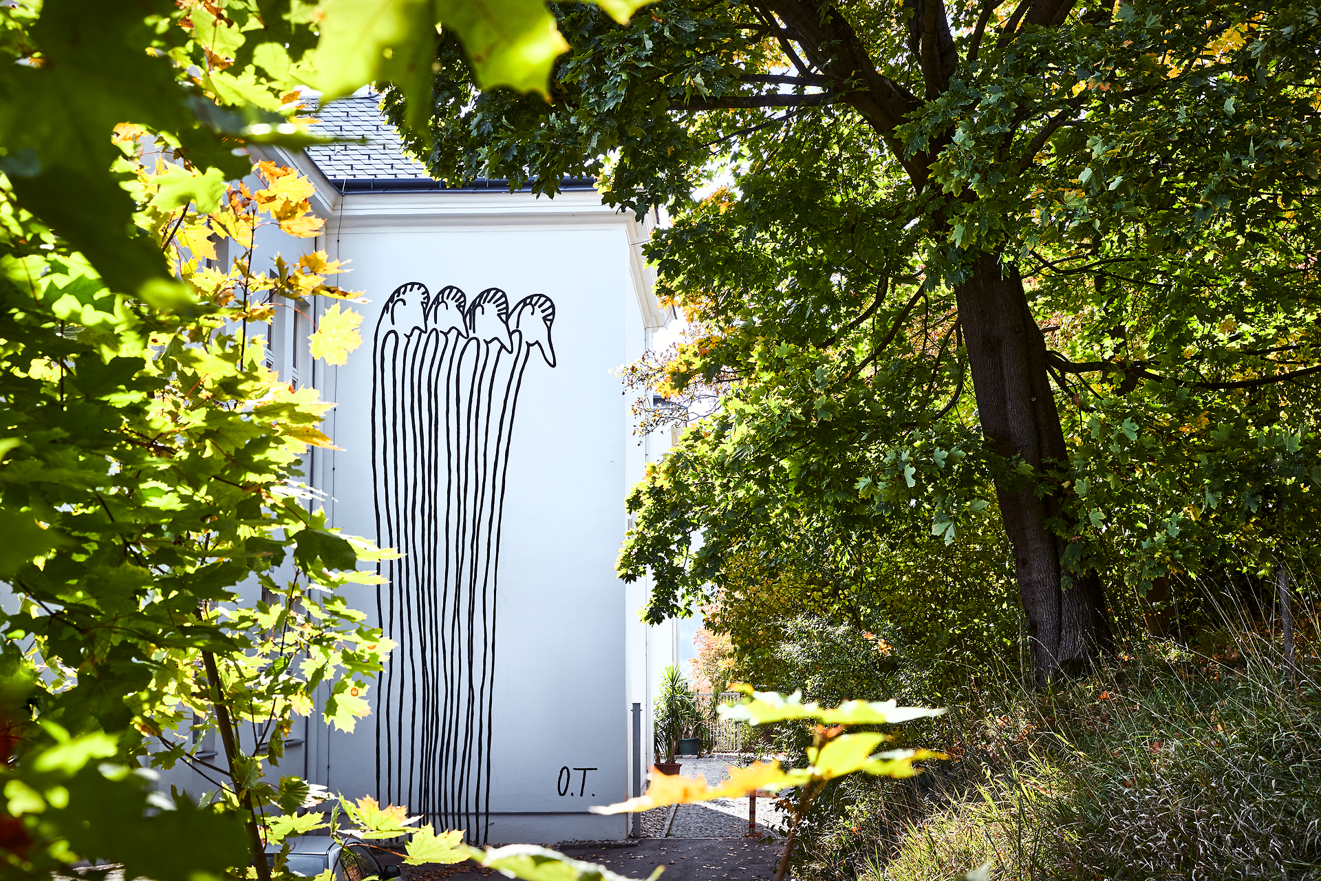 Inmitten der üppigen Natur des Wienerwaldes erhebt sich eine faszinierende Wandmalerei, die die Fantasie anregt. Die stilisierten Figuren scheinen in einem harmonischen Dialog mit der Umgebung zu stehen und laden dazu ein, die kreative Energie des Ortes zu spüren. Ein Besuch hier verspricht nicht nur visuelle, sondern auch emotionale Erlebnisse.