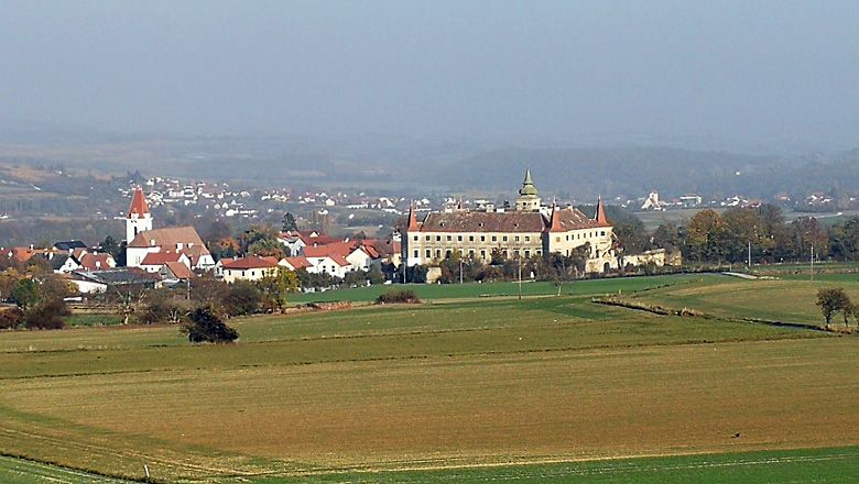 Landschaft mit Kirche und Schloss in der Ferne.